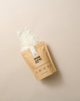 Noa & Co Vanilla Collagen Creamer pouch, with powder pouring out