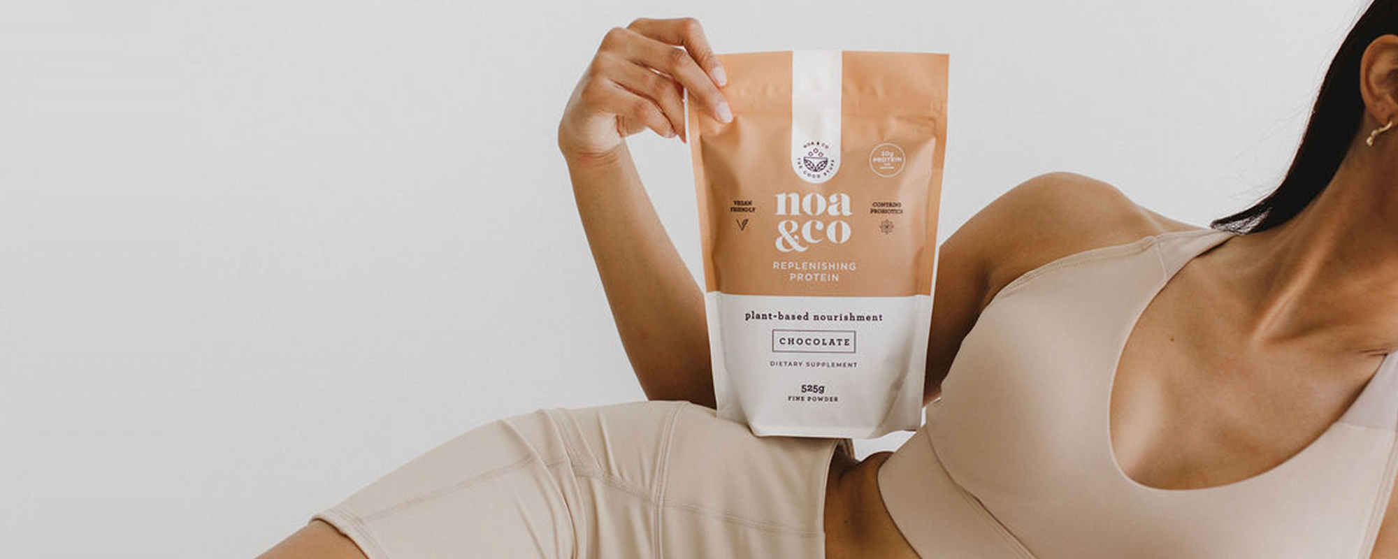 Chocolate Plant-based Vegan Protein powder being held by a woman | Noa & Co