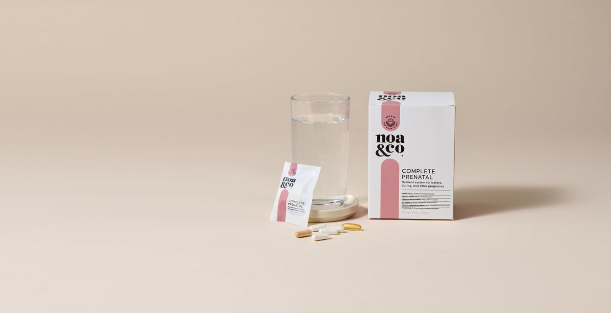 Noa & Co Complete Prenatal box, sachet and capsules beside a glass of water