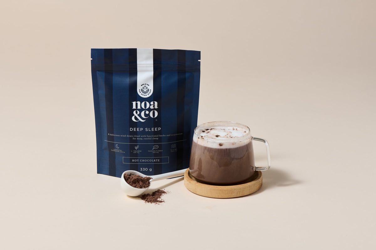 Deep Sleep Hot Chocolate pouch with a scoop and a mug of hot chocolate